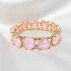 Soft pink crystal bead stretch bracelet with heart-shaped stones and gold-tone links