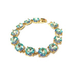 Gold-tone crystal bracelet with aqua and iridescent round cushion stones and hinge clasp.