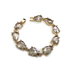 Teardrop crystal link bracelet with gold-tone settings and clear smoky glass stones.