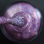 Pink holographic glitter nail polish topper in a small bottle with glitter