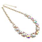 Gold-tone linked chain necklace with cushion-cut multi-color crystal stones, oval clasp