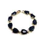 Teardrop crystal link bracelet with gold-tone settings and dark blue glass stones.