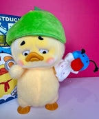 Plush duck figure in bright green cap holding small red-and-blue plush