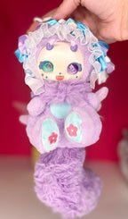 Purple plush angel blind box doll with frilled hood, ribbon bows, and star motifs