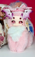 Fantasy creature plush blind box with pink fur, purple wings, and lace-trim hood
