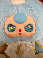 Blue bunny plush face with glitter eyes and blue nose, wearing white dress