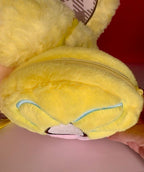 Yellow plush donut-shaped backpack front with blue stitched heart nose detail