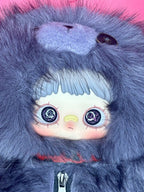 Blue-gray fuzzy hooded plush backpack close-up with doll face and zipper