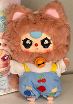 Plush tan baby kitten in light-blue overalls with fruit graphics and orange chest pendant