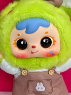 Close-up green rabbit plush face with large black eyes, blue hood brows, brown overalls