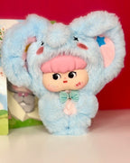 Light blue plush animal pendant with big ears, sleepy face patch, and teal bow.
