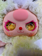Close-up of plush bunny backpack face with pink cheeks and gold glitter eyes