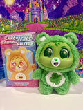 Green plush bear vinyl pendant with white belly and clover emblem, keychain-style loop