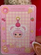 Pink blind box package card with illustrated white bear hooded character in ice cream cone