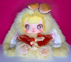 Lemon-yellow plush doll with bear-like hood, wide-eyed face, red dress and ruffled collar