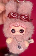 Light pink plush keychain with metallic red bow, rabbit charm necklace, and glossy face