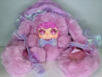 Lilac plush doll with jellyfish-style hood, holographic ribbon ruffles and bow