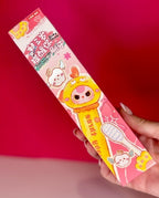 Character toothbrush blind box package with cute face graphic, pink and yellow