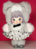 Gray plush articulated doll front view with bear-ear hood, lilac hair, black bow collar