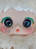Close-up of white plush lamb face with large glittery eyes and teal cheek accents