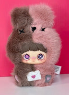 Collectible plush doll with brown fuzzy bear suit and gray hair holding a heart note