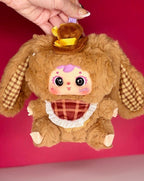 Brown plush bunny pendant with yellow hat and plaid apron, held by keychain loop