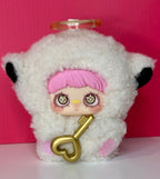 Collectible plush doll with white fur hood, pink hair, and gold key-shaped accessory