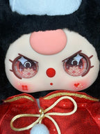 Close-up face of collectible plush groom doll with rosy cheeks and red dot details