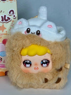 Beige plush food pendant with big eyes and yellow frosting-style hood detail
