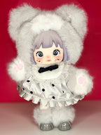 Articulated plush doll with white bear hood, black bow dress, and gray slippers.