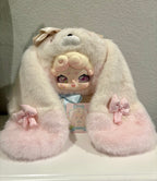 Cream plush rabbit with long ears, pink face, blue bow at chest, embroidered paw details