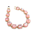 Gold-tone crystal bracelet with light pink round cushion stones and hinge clasp.