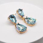 Gold-tone crystal teardrop dangle earrings with light blue oval and pear stones