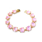 Gold-tone crystal bracelet with pink round cushion stones and hinge clasp.