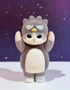 Flocked gray character figure with sleepy eyes and small yellow forehead marking