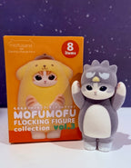 Flocked gray character figure next to orange Mofumofu collection box