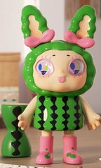 Green bunny-themed vinyl blind box figure with pink bows, pink boots, and black pattern top