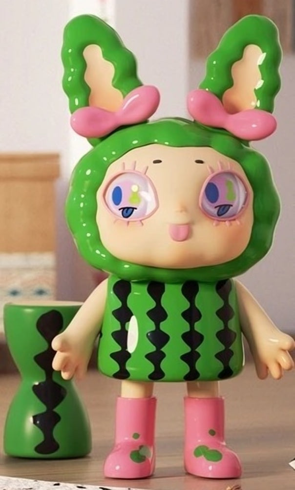 Green bunny-themed vinyl blind box figure with pink bows, pink boots, and black pattern top