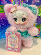 Close-up pink plush cat keychain with gold ring, turquoise bow, pearl collar