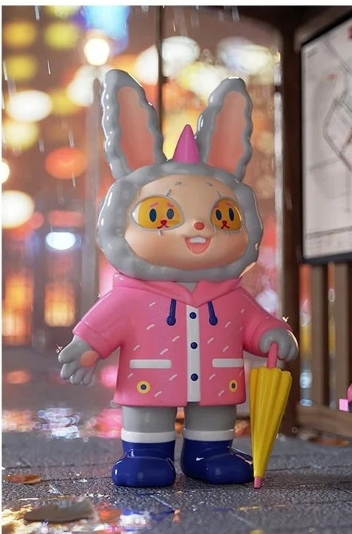 Gray bunny-style blind box figure in pink jacket, blue shoes, holding a yellow cone