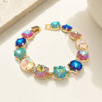Gold-tone crystal bracelet with multicolor round cushion stones and hinge clasp.
