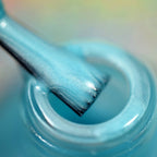 Sky blue nail polish close-up showing glossy creme swirl in bottle