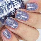 Holographic glitter nail polish on several nails, purple-silver rainbow sparkle