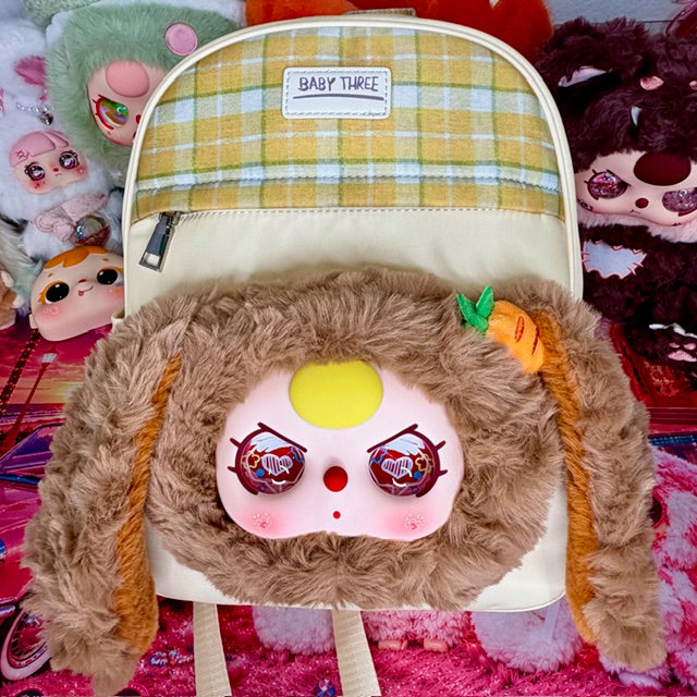 Plush kids backpack with brown fuzzy body, plaid top panel, and cartoon face