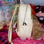 Cream kids backpack side view with vertical zipper and adjustable shoulder strap