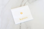 Katatora jewelry card showing gold-tone earring stud