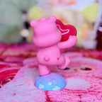 Back view of the pink Care Bears figure on a blue cloud base, with a red heart accessory