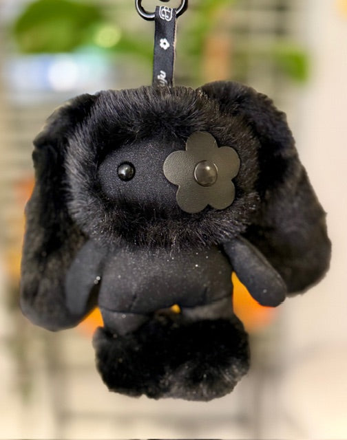 Hanging black plush rabbit bag charm with metal flower face badge and small eyes