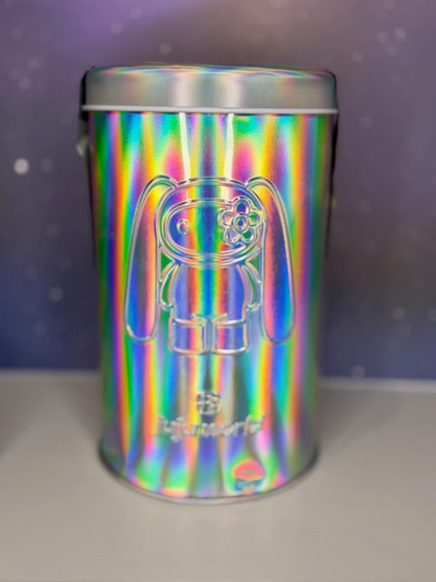 Holographic silver tin with rabbit graphic front and “Juju world” text at bottom