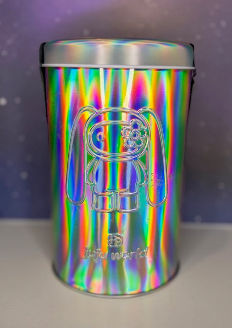 Holographic silver tin with rabbit graphic front and embossed “Juju world” text